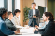 © chokniti - Business meeting team office coworker collaboration leader discussion corporate professional startup business meeting with diverse team bright modern office, confident female leader guiding