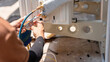 © iPoguz - Professional technician installing outdoor air conditioning unit and connecting copper pipes, Close up of air conditioning installation process, vacuuming and connecting hose by specialist