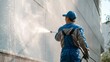 © Lubos Chlubny - Worker pressure washing building facade with high pressure cleaner