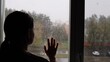 © Anastasiya - Sad woman looking through a rainy window. A lonely young woman looks out the window in depression