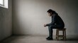 © Ramdani - Woman sitting alone in a room looking contemplative