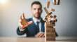 © Jabalenour - Businessman trying to catch falling wooden blocks during crisis