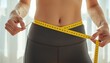 © geniuskp - There is a woman measuring her waist with a yellow tape