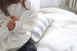 © webbiz - ベッドの傍らで胸を押さえ苦しむ女性　動悸や息苦しさ