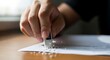 © Vektor Stokart - Closeup of a hand using an eraser to remove pencil marks from a document on a wooden desk
