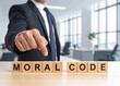 © magele-picture - Moral Code - Geschäftsmann zeigt auf den Text 'moral Code'