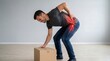 © Flash memory - Man suffering from lower back pain while lifting heavy cardboard box. Spinal injury and muscle strain anatomy visualization. Healthcare concept for orthopedic treatment and relief.
