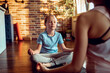 © Davor - Girl meditating with parent on yoga mat at home