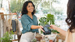 © lucas - Smiling Female Vendor Accepting Contactless Credit Card Payment at Outdoor Market