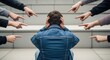 © mlangsen - A person sits, head down, hands over ears, surrounded by accusing fingers pointing
