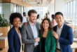 © Meow Creations - Diverse team of professionals smiling in modern office