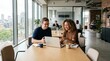 © ameliabusinessstock - Two smiling colleagues working together on a laptop in a well-lit contemporary office space. Ideal for business, teamwork, remote work, and corporate marketing content