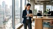 © ameliadimufah - Professional businesswoman using tablet in modern office with city skyline view