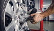 © Nadya - Auto Mechanic Adjusting Wheel Alignment on Car Tire in Automotive Service Workshop