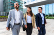 © Westend61 - Smiling coworkers walking together outdoors at financial district