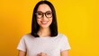 © WS Studio 1985 - Radiant Woman in Glasses: A beautiful woman with dark hair and stylish glasses smiles warmly against a bright yellow backdrop. A portrait of modern elegance and genuine happiness.