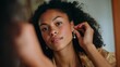 © GATE 22 - Close-up portrait of a young woman with curly hair. she is looking directly at the camera with a slight smile on her face. her hair is styled in loose curls and she is wearing a gold top.
