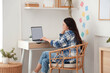 © Pixel-Shot - Young woman working with blank laptop at table in office