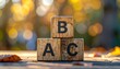 © Rat Art - Wooden blocks spell out ABC, stacked neatly. Autumn leaves scatter around the base