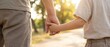 © Aurora Aesthetics - child adult support walking hands family care trust closeup with caregiver and child holding hands on sunlit path suggesting guidance protection connection and safe childhood journey