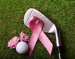 © Thomas - golf club and ball with pink ribbon and flowers for breast cancer awareness on green grass surface