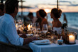 © Milos - An elegant beach dinner setting showcasing a table adorned with fine dishes and decorative elements, offering guests a tasteful dining experience by the ocean at sunset.