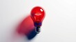 © StasySin - Red light bulb shines brightly against stark white background. Its filament glows with warm, inviting energy. Shadow casts bold red hue onto clean surface