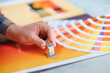 © Serhii - Printer hand checking color swatches with loupe