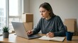 © Olga - Young woman working on laptop and taking notes at home desk