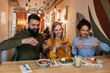 © La Famiglia - Friends capturing brunch food with smartphones in cafe