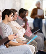 © JackF - People of different ages sit together in line waiting for an interview at a prestigious company. After the dismissals, men and women came to apply for a vacancy