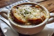 © farah - Close-up shot of a white dish of Cozy Crockpot French Onion Soup on a wooden table in natural sunlight