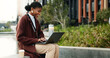 © peopleimages.com - Businesswoman, smile and remote work in city with laptop, typing and copywriting for email marketing. Happy, black person or freelancer in urban town with computer, draft newsletter and SEO campaign.