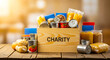 © rima - Wooden crate filled with donated food items and labeled charity, canned goods