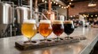 © Masque - Craft beer flight tasting sampler with four different ales on a wooden board in a modern brewery taproom.