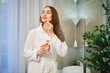 © boomeart - Woman applying lip balm in bathroom after showering in a home setting