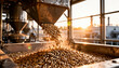 © maxximmm - Grains flow from a machine into a large container. The scene captures the industrial operation of grain processing at sunset, highlighting the golden grains.
