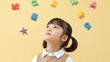 © bephoto - 知育アイテムを見上げる日本人の女の子の学習イメージ写真