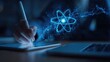 © Fauzi - Digitally drawing atom with stylus on tablet, futuristic blue glow