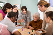 © JackF - Engaged men and women of different ages playing tabletop game during interactive workshop indoors