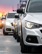 © Lemari - A row of cars parked along a road at sunset