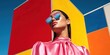© Yevheniiya - Stylish young woman in pink satin dress and reflective sunglasses against colorful geometric background