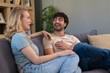 © Dexon Dee - Happy young couple laughing, talking on couch at home