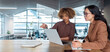 © Stock 4 You - Two professional women, businesswomen in modern open-plan office workspace collaborating at laptop, discussing business work on computer pc screen and taking notes at a desk. Web banner, copy space