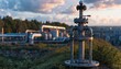© Justlight - Medium shot of a landfill gas wellhead with blurred piping and equipment on a slope under dusk sky capturing industrial focus amid soft natural light.