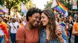 © velikiyzayats - Happy young diverse women couple embracing at outdoor pride parade celebration
