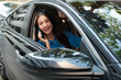 © Parichat - Smiling woman driving car talking on smartphone