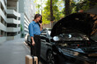© Parichat - Woman calling for roadside assistance after car breakdown
