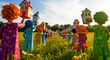 © CLAESSENS THOMAS FIL - Whimsical colorful figures holding miniature houses in a sunny flower meadow. Artistic clay-style characters carrying toy homes represent community growth. Ideal for real estate and housing marketing.