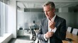 © Zero One Studio - 50 years old business man company manager adjusting suit tie in modern office corridor with glass walls and bright natural light and copy space. He is preparing for a meeting.